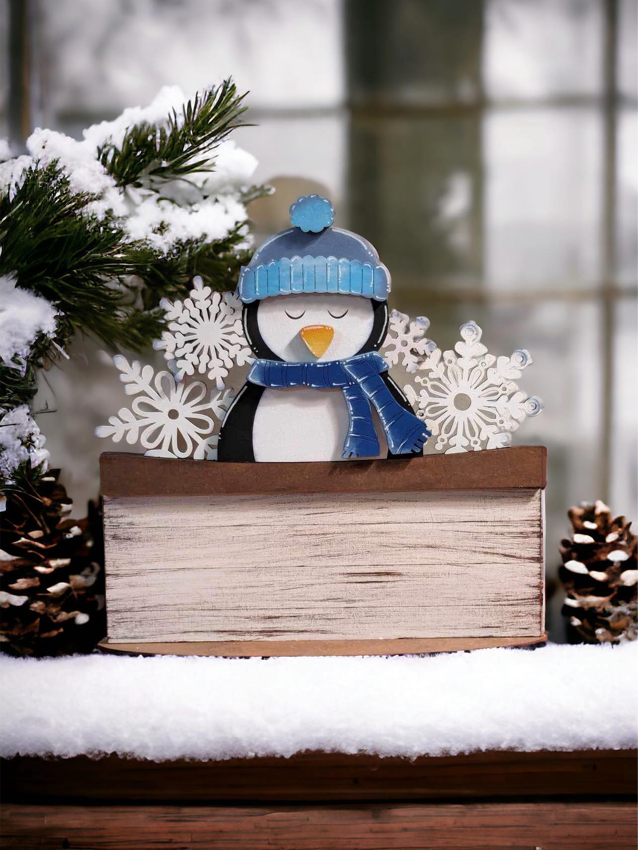 penguin with blue hat next to snowflakes