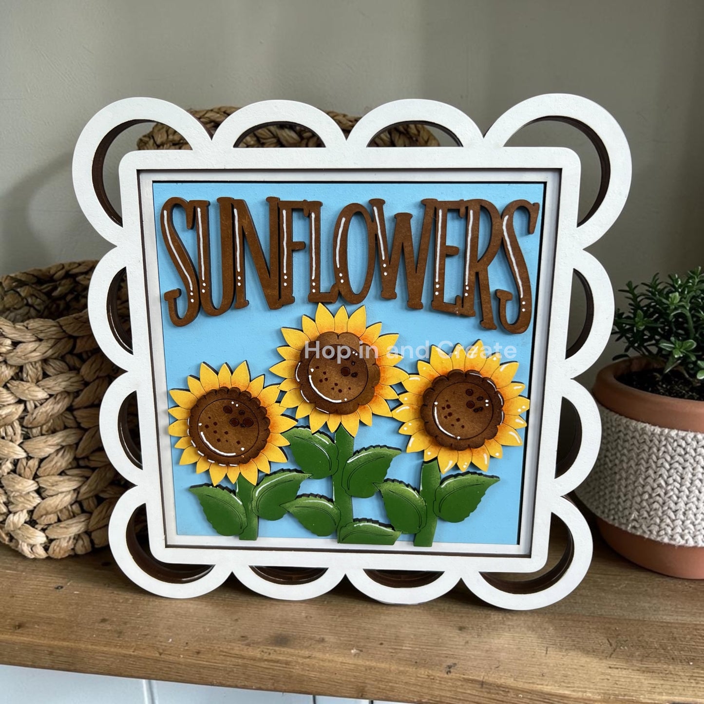 Decorative sign with sunflowers and 'Sunflowers' text on a wooden surface.