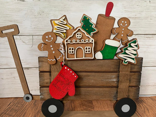 A decorative gingerbread basket insert featuring various Christmas-themed cookies such as Santa, a reindeer, and a gingerbread house, placed in a wooden basket with a red and white color scheme.