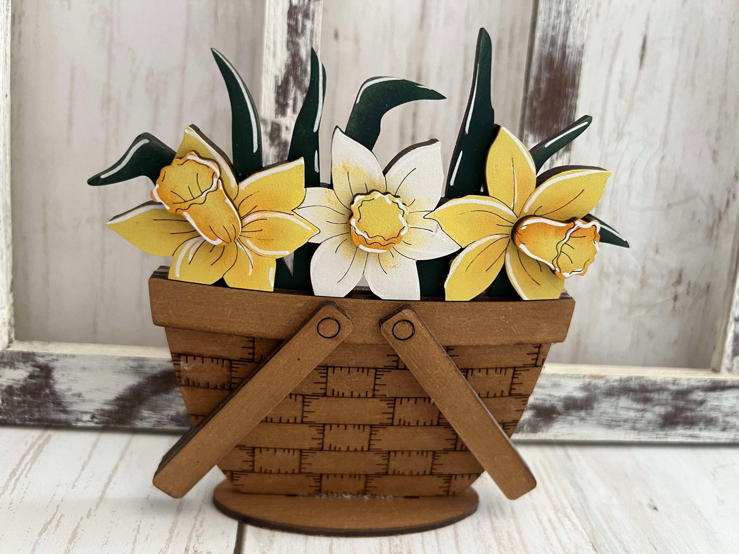 A decorative basket insert with a standing design featuring yellow and white daffodils.