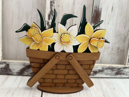 A decorative basket insert with a standing design featuring yellow and white daffodils.