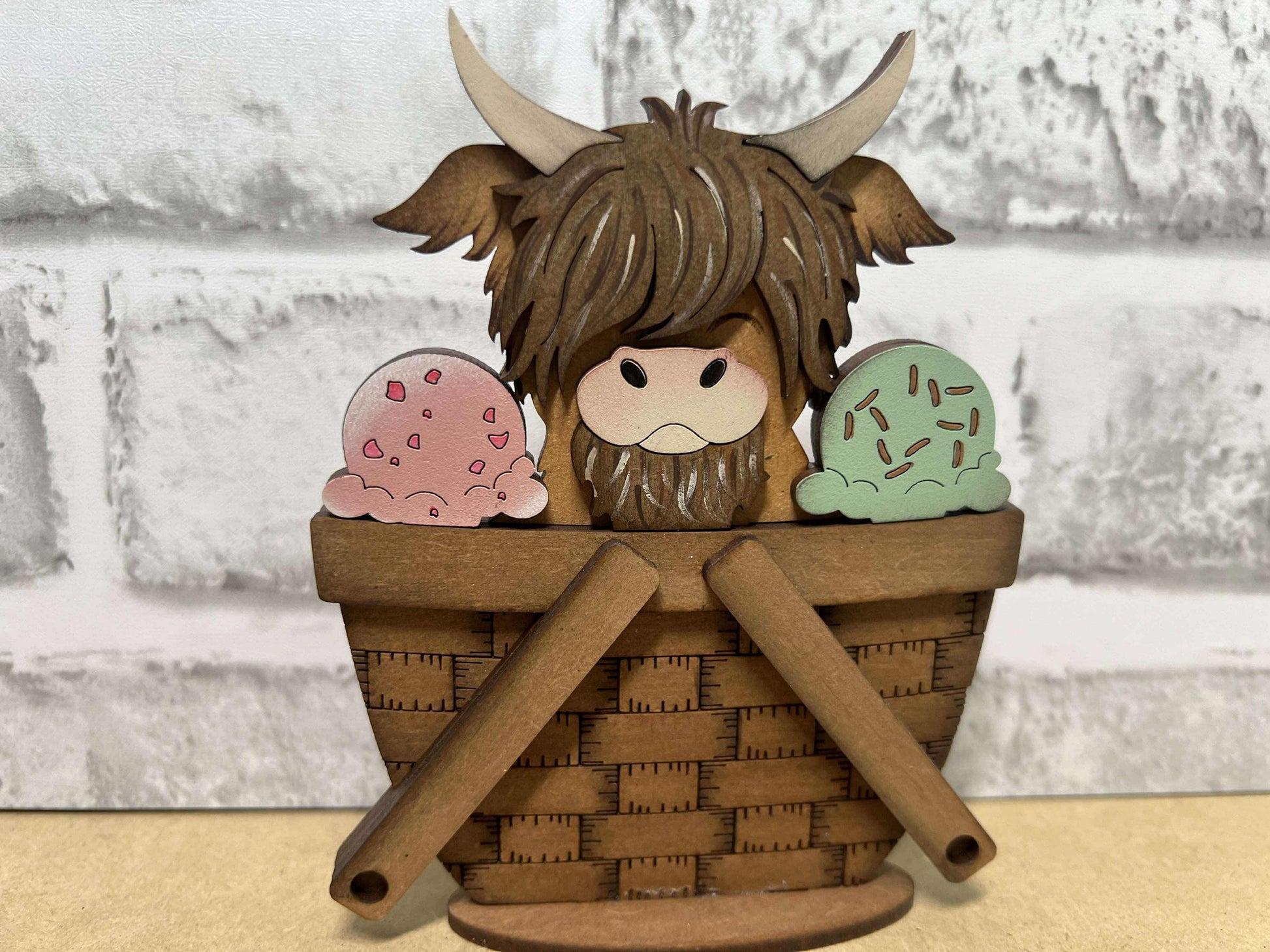 A decorative basket insert with a highland cow and ice cream design.