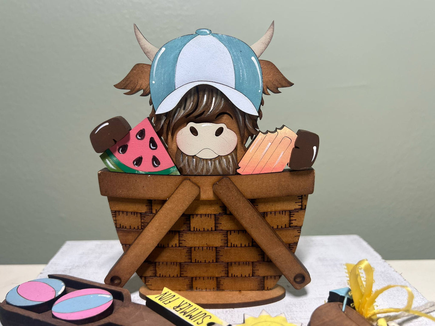 highland cow in a basket with summer items 