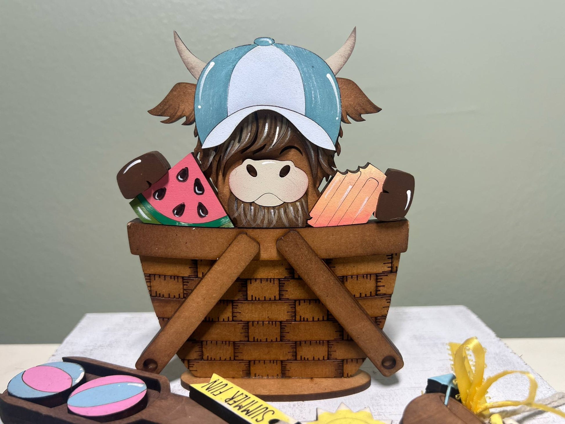 highland cow in a basket with summer items 